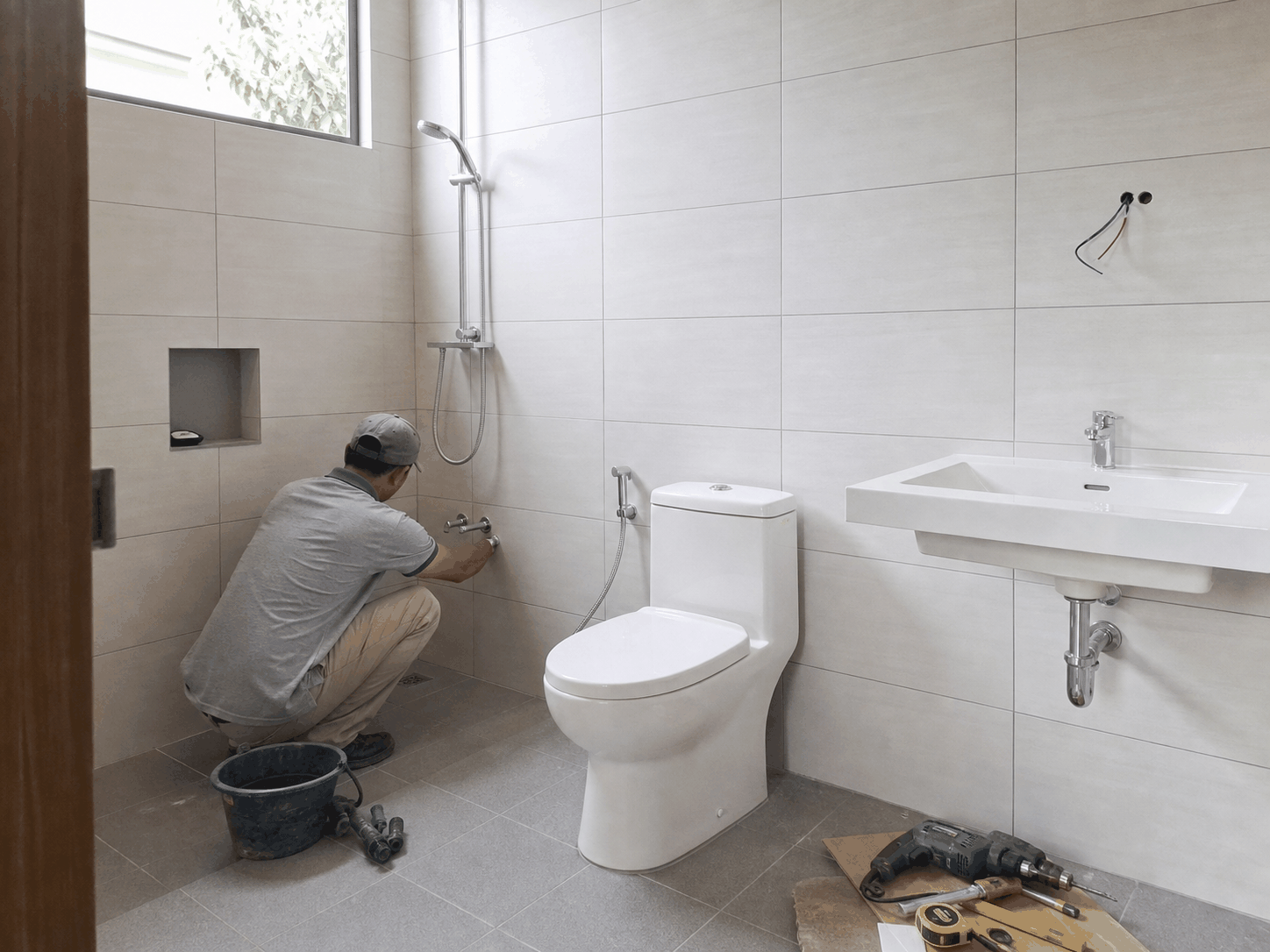 Pekerja memperbaiki instalasi air kamar mandi